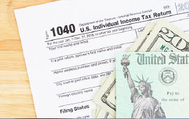 1040 tax form with money sitting on top